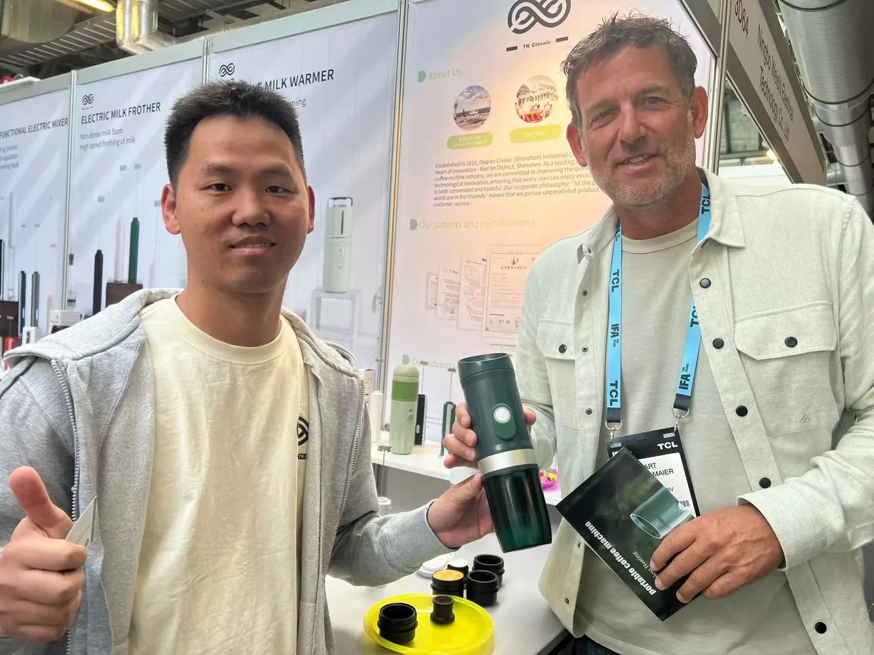 Portable coffee machine being demonstrated to a visitor at an exhibition