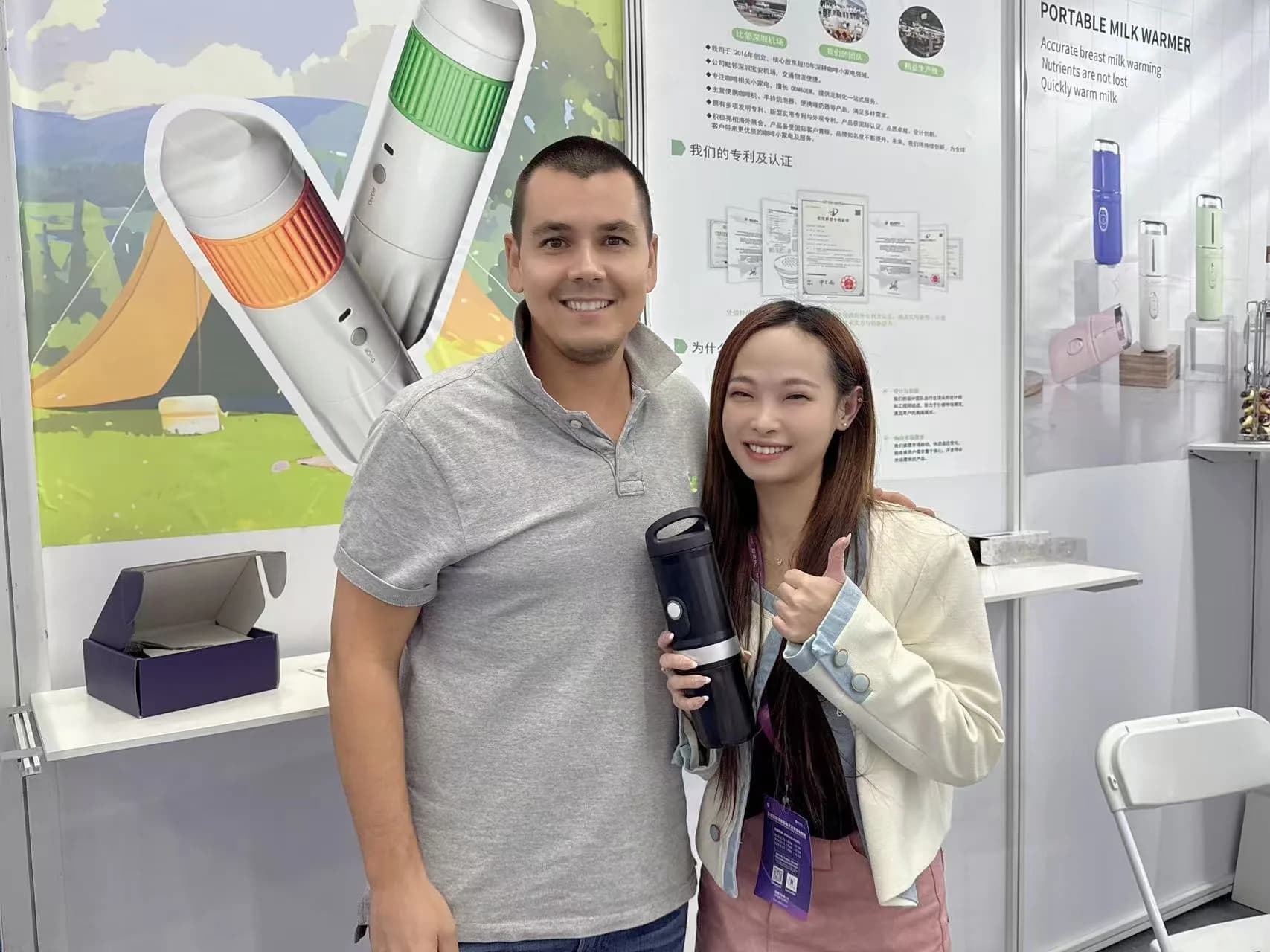 Visitor and TK Classic representative holding a portable coffee machine at an exhibition