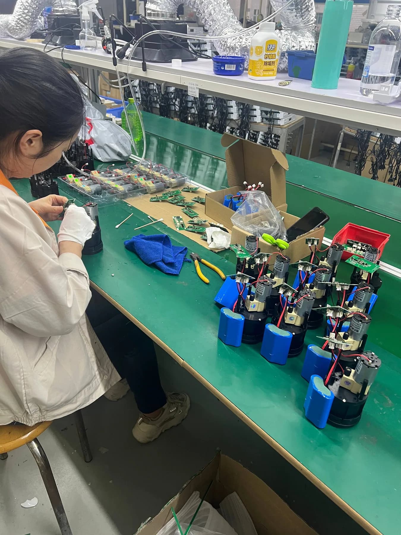 Operator assembling portable coffee machine core modules at a workbench