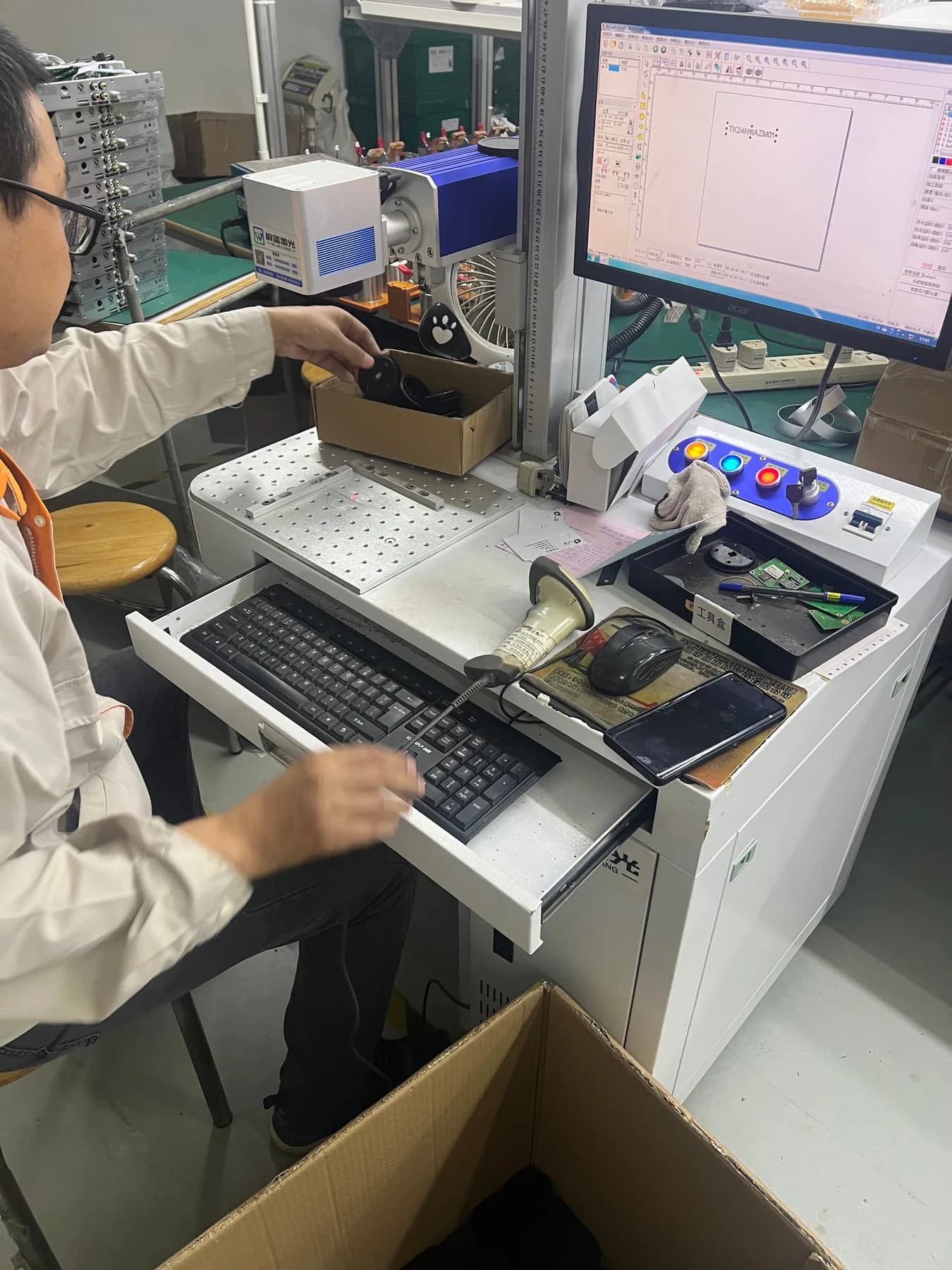 Operator using a laser marking workstation for a portable coffee machine component